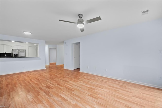 unfurnished living room featuring ceiling fan and light hardwood / wood-style flooring