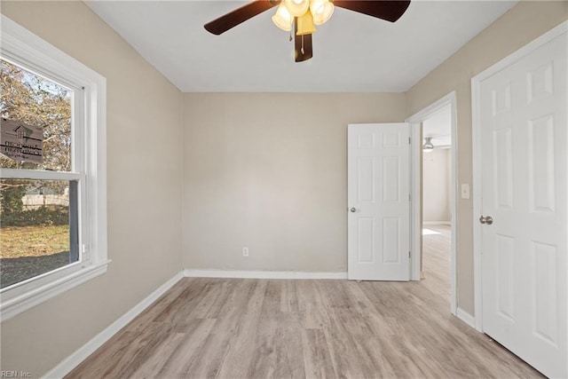 unfurnished room featuring light hardwood / wood-style floors, a wealth of natural light, and ceiling fan