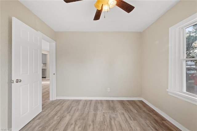 spare room with ceiling fan and light wood-type flooring