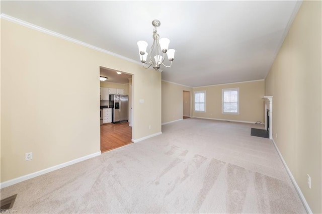 carpeted spare room with a chandelier and ornamental molding