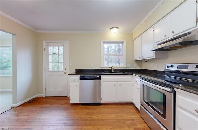 kitchen with white cabinets, stainless steel appliances, light hardwood / wood-style flooring, and ornamental molding