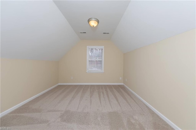 additional living space featuring light carpet and lofted ceiling