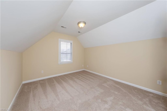 additional living space with light colored carpet and lofted ceiling