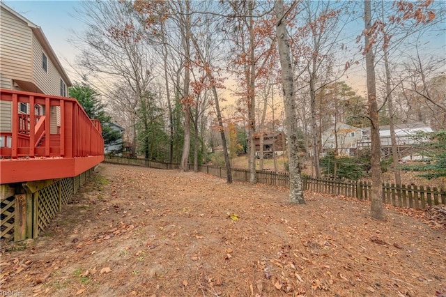 yard at dusk featuring a deck