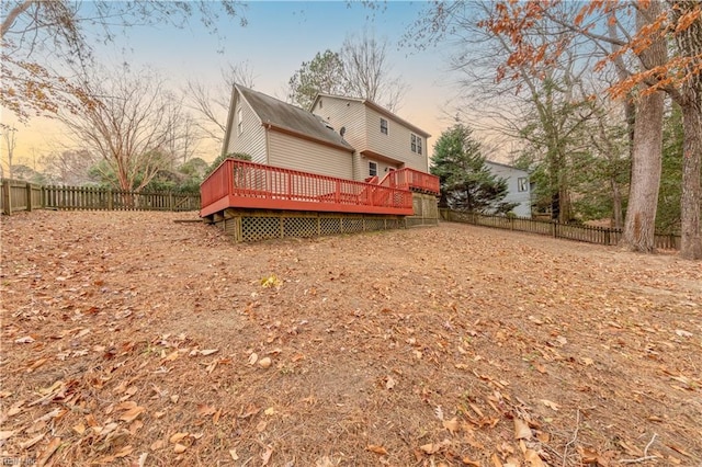 back house at dusk with a wooden deck