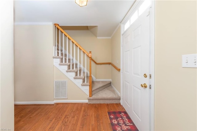 entrance foyer with hardwood / wood-style floors and crown molding