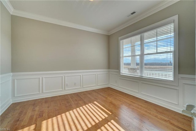 unfurnished room with light wood-type flooring and ornamental molding