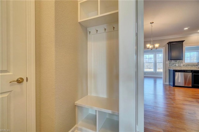 mudroom featuring an inviting chandelier, light hardwood / wood-style flooring, and crown molding