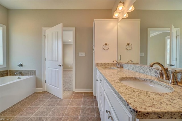 bathroom with a bathing tub, tile patterned flooring, and vanity