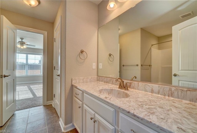 bathroom with tile patterned floors, ceiling fan, vanity, and walk in shower