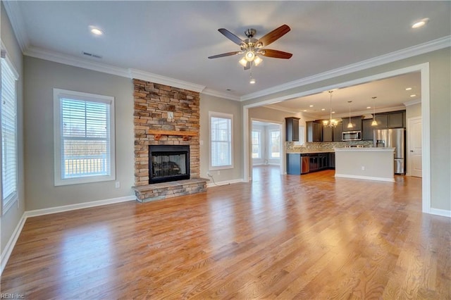 unfurnished living room featuring ornamental molding, a healthy amount of sunlight, and light hardwood / wood-style floors