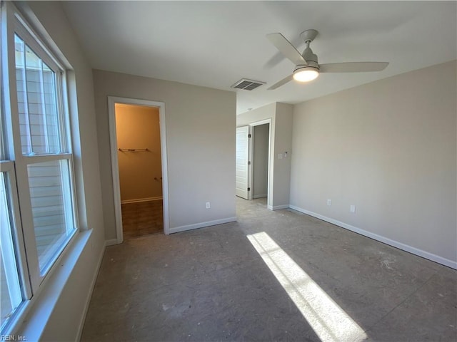 unfurnished bedroom with ceiling fan, a closet, and a spacious closet