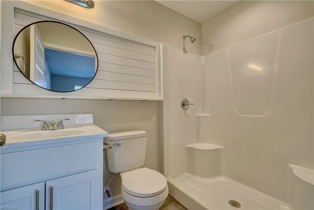 bathroom featuring a shower, toilet, and vanity