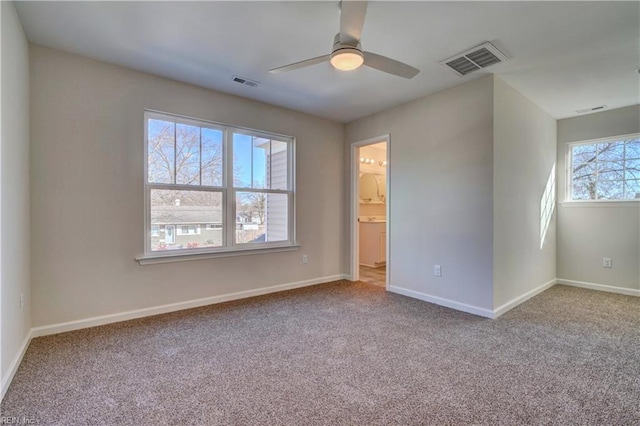 carpeted empty room featuring ceiling fan and plenty of natural light