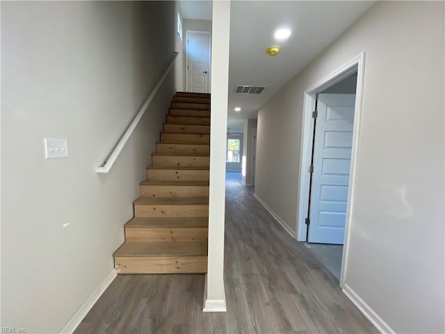 stairs featuring hardwood / wood-style floors