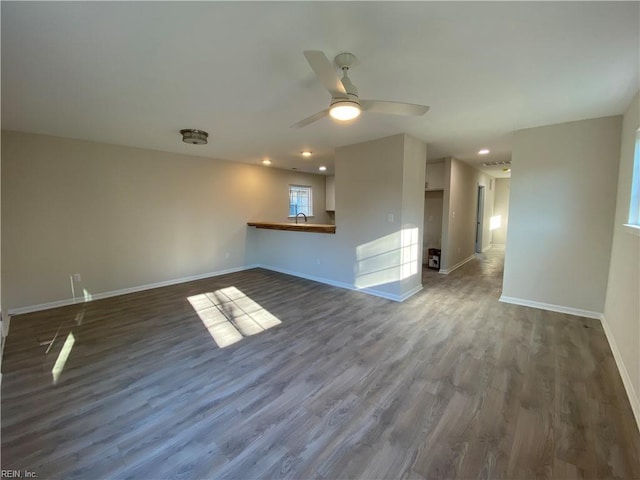 unfurnished living room with ceiling fan, dark hardwood / wood-style floors, and sink