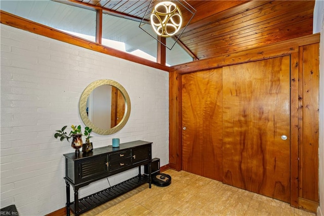 foyer with wood ceiling, brick wall, and vaulted ceiling