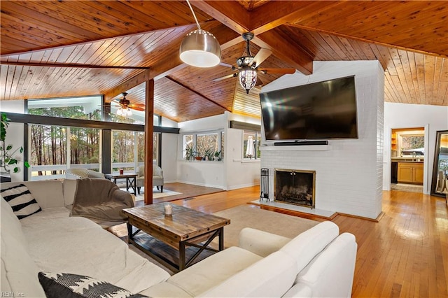 living room featuring vaulted ceiling with beams, light hardwood / wood-style floors, and a wealth of natural light