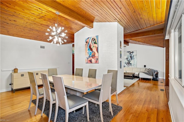 dining area with vaulted ceiling with beams, an inviting chandelier, light hardwood / wood-style flooring, and wooden ceiling