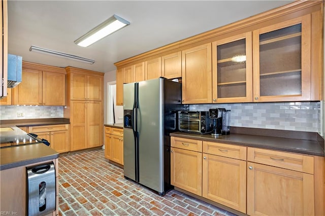 kitchen with stainless steel fridge and tasteful backsplash