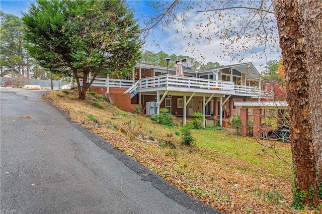 front facade with a wooden deck and central AC unit