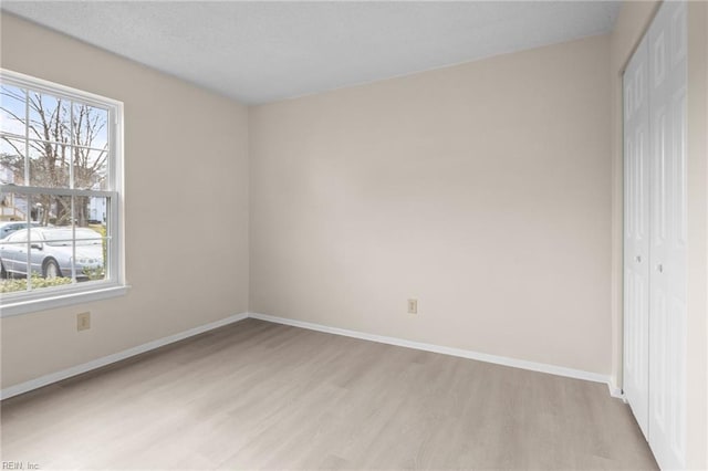 unfurnished bedroom featuring a closet and light wood-type flooring