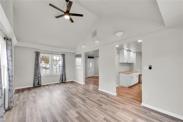 unfurnished living room with light wood-type flooring, high vaulted ceiling, and ceiling fan