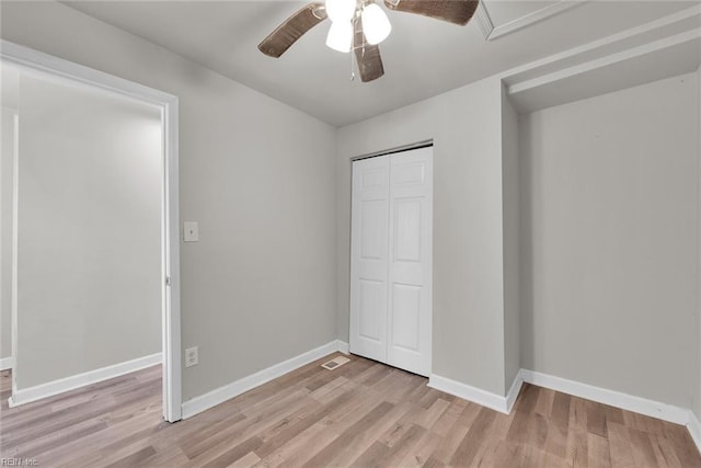 unfurnished bedroom featuring a closet, light hardwood / wood-style floors, and ceiling fan