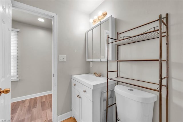 bathroom with vanity, toilet, and wood-type flooring