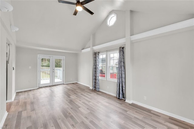 empty room featuring french doors, high vaulted ceiling, and light hardwood / wood-style floors