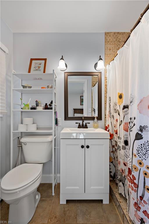 bathroom featuring vanity, toilet, and curtained shower