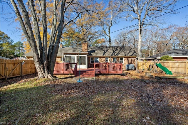 rear view of property featuring a wooden deck and a sunroom