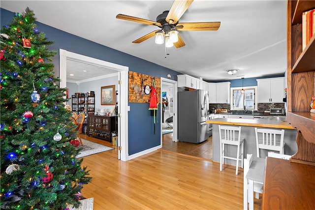 kitchen featuring kitchen peninsula, stainless steel fridge with ice dispenser, light hardwood / wood-style flooring, and white cabinetry