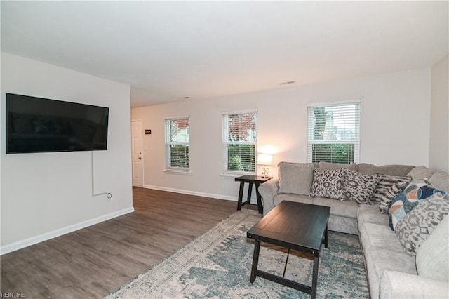 living room featuring plenty of natural light and dark wood-type flooring