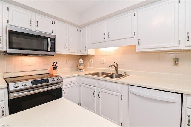 kitchen featuring backsplash, stainless steel appliances, white cabinetry, and sink