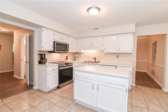 kitchen with white cabinetry, sink, a center island, and stainless steel appliances