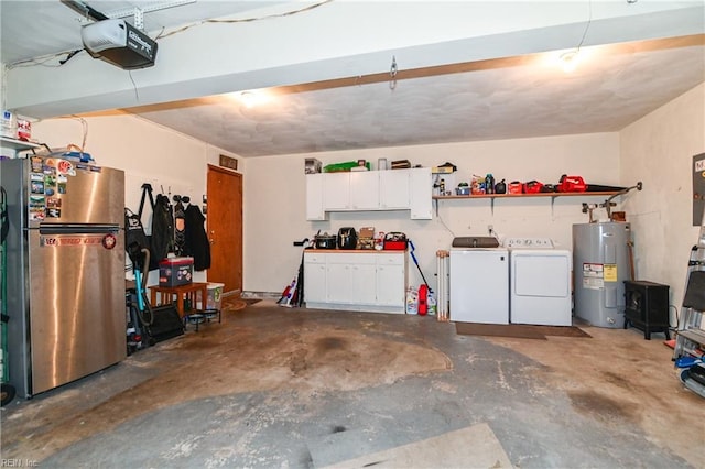 garage with a garage door opener, electric water heater, stainless steel refrigerator, and washing machine and clothes dryer