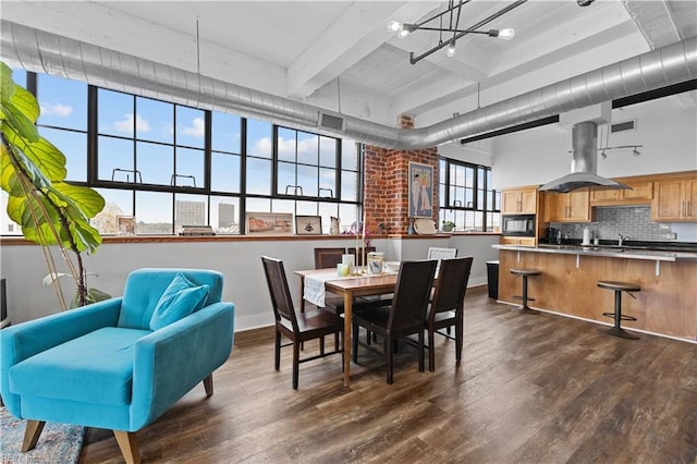 dining room featuring beam ceiling, sink, a chandelier, and dark hardwood / wood-style floors