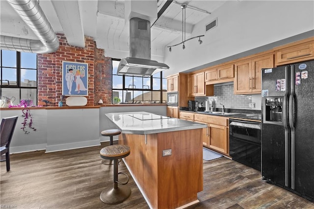 kitchen with a center island, dark wood-type flooring, plenty of natural light, island range hood, and black appliances