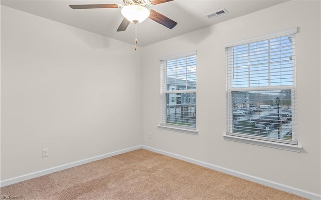 carpeted spare room featuring ceiling fan