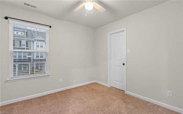 carpeted spare room with ceiling fan