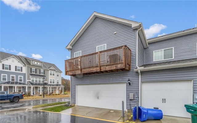 back of property with a balcony and a garage