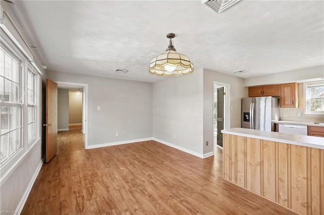 kitchen with dishwasher, stainless steel fridge with ice dispenser, decorative light fixtures, and light hardwood / wood-style flooring