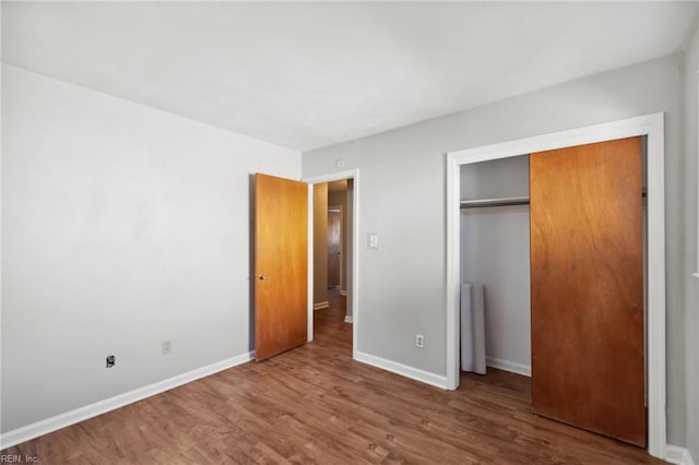 unfurnished bedroom featuring a closet and hardwood / wood-style flooring