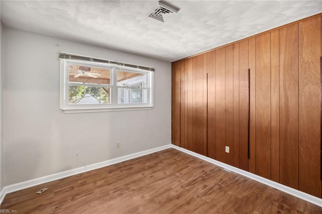 unfurnished room with hardwood / wood-style floors