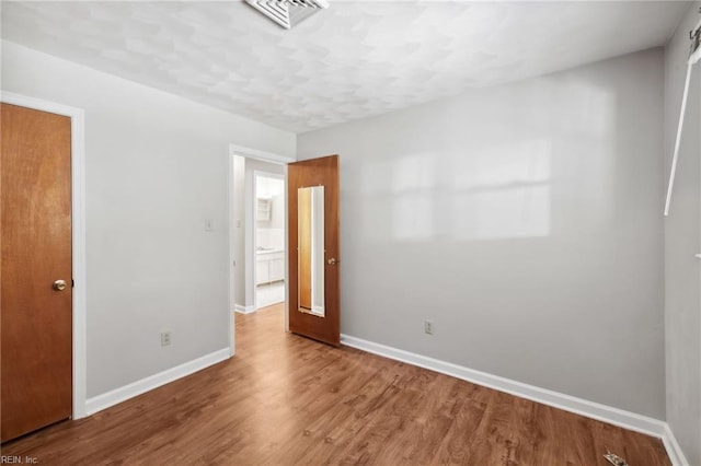 empty room with hardwood / wood-style flooring