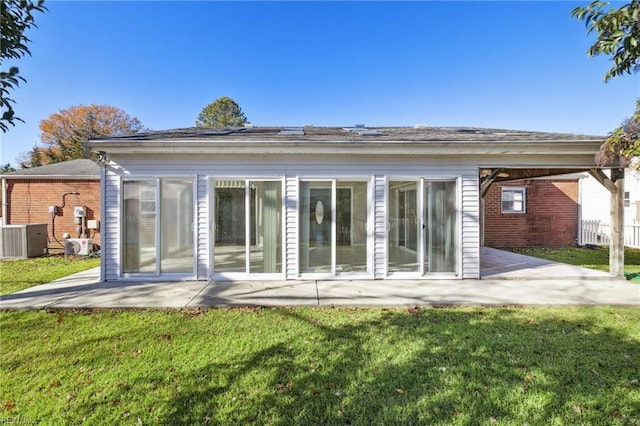 rear view of house with a yard, central AC unit, and a patio area