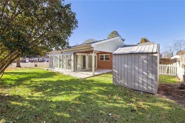 rear view of house featuring a lawn and a patio