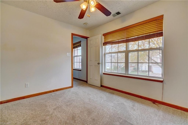 spare room with carpet flooring, a textured ceiling, and ceiling fan