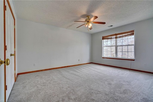 empty room featuring carpet, a textured ceiling, and ceiling fan